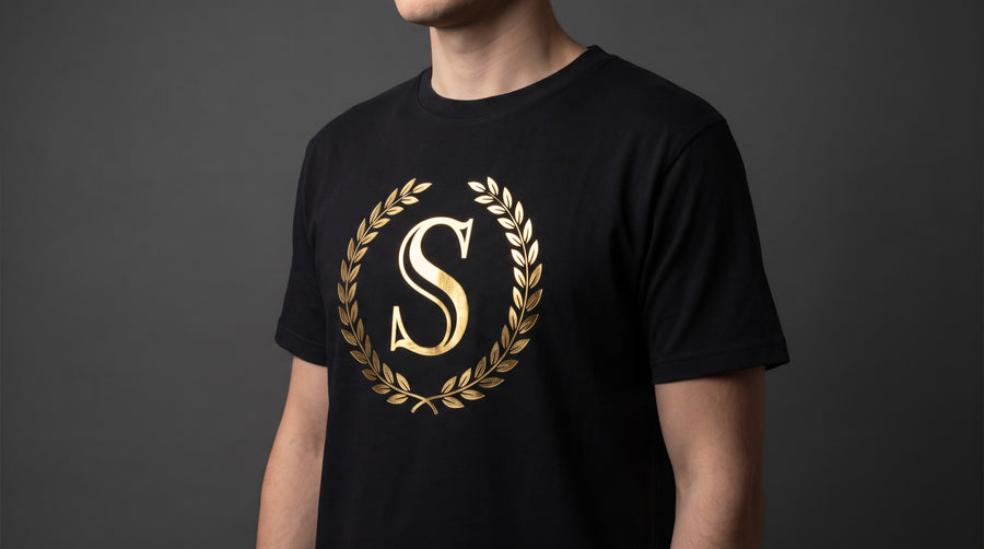 Tricou negru cu monogramă aplicată cu film DTF metalizat auriu